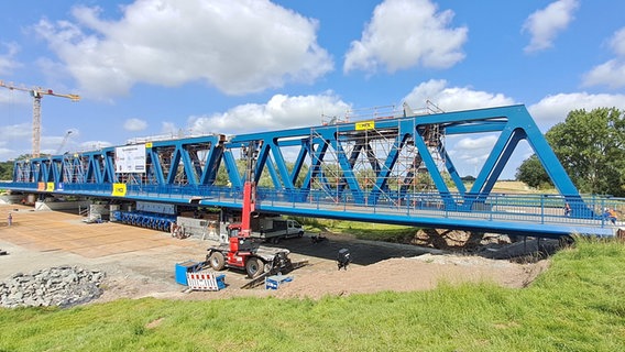 Mehrere zusammengebaute Segmente eines ersten Teils der neuen Friesenbrücke stehen an der Brückenbaustelle bei Westoverledingen (Landkreis Leer) an der östlichen Emsseite in Ostfriesland. © picture alliance/dpa/DB InfraGO 