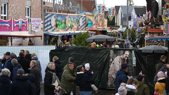 Einsatzkräfte haben auf dem Gallimarkt einen Sichtschutz aufgebaut. Am Nachmittag war ein Fahrgeschäft in Brand geraten. © Lars Penning/dpa Foto: Lars Penning