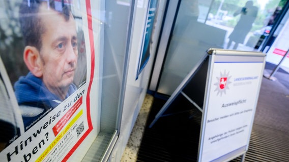 Ein Fahndungsplakat mit einem Foto von Burkhard Garweg hängt im Eingangsbereich vom Landeskriminalamt Niedersachsen. © Julian Stratenschulte/dpa Foto: Julian Stratenschulte