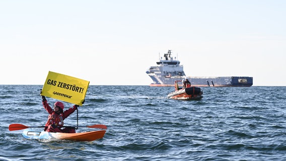 Einen Banner mit "Gas Zerstört" hält ein Greenpeace-Aktivisten auf der Nordsee in die Höhe (Protest gegen Förderung von Erdgas vor Borkum). © dpa-Bildfunk Foto: Lars Penning
