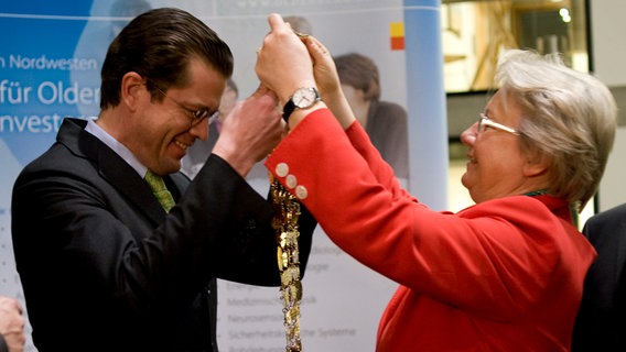 Anette Schavan (CDU) überreicht am 22.03.2010 in der Landesvertretung Niedersachsens in Berlin Karl-Theodor zu Guttenberg (CSU) die Insignien der Kohlmajestät. Als Oldenburger Grünkohlkönig 2010 übernahm Guttenberg die Amtsgeschäfte von seiner Vorgängerin. © picture alliance / dpa | Klaus-Dietmar Gabbert Foto: Klaus-Dietmar Gabbert