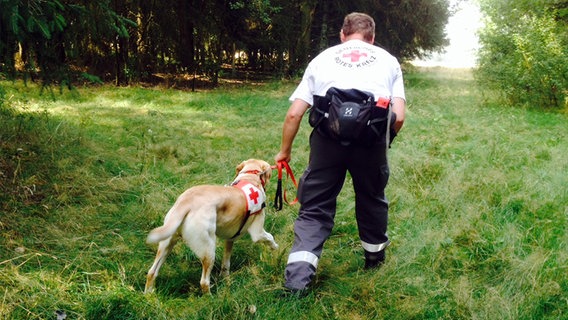 Ausbilder Daniel Dietrich vom DRK führt Rettungshund "Oskar" an der Leine. © NDR Foto: Alice Abed el Sayed