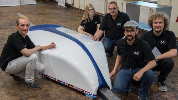 Studenten und ein Professor des HyperPod-Projektes der Oldenburger Universität und der Hochschule Emden-Leer stellen die neu eingetroffene Karosserie ihres HyperPod vor. © dpa-Bildfunk Foto: Ingo Wagner