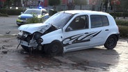 Ein Kleinwagen steht nach einem Unfall mit einem Ampelmast in Jever an einer Straße. © Nord-West-Media TV 