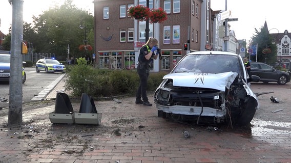 Ein Kleinwagen steht nach einem Unfall mit einem Ampelmast in Jever an einer Straße. © Nord-West-Media TV 