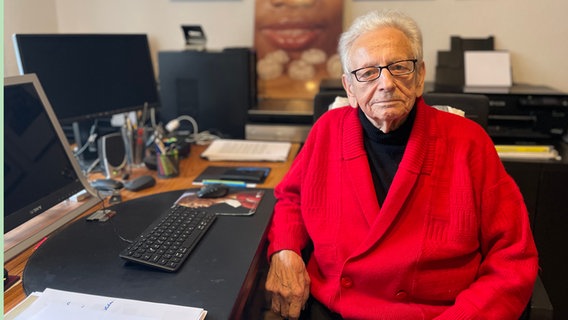 Josef Albert Slominski sitzt an einem Tisch. © NDR Foto: Catherine Grim