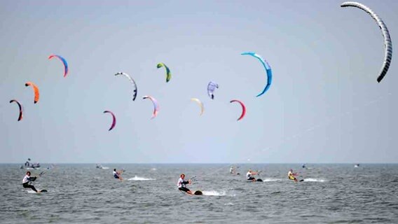 Kitesurfer starten am Strand von St. Peter-Ording in der Nordsee. © dpa Foto: Angelika Warmuth