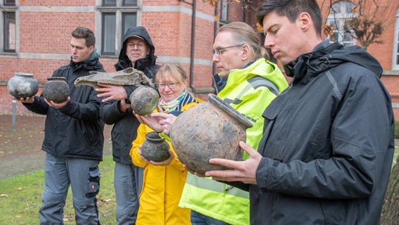 Viacheslav Hladkyi, Johann Arends, Claudia Neutzer, Dr. Jan F. Kegler und Taras Khromushyn zeigen die ungewöhnlich gut erhaltenen Kugeltöpfe aus dem Spätmittelalter und einen Pferdeschädel, die bei den Grabungen auf der Japaninsel gefunden wurden. © Ostfriesische Landschaft 