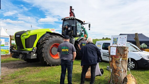 Besucher der Messe LandTageNord betrachten einen Traktor © NDR Foto: Birgit Stamerjohanns