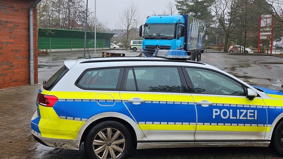 Im Vordergrund steht ein Polizeiauto, im Hintergrund der Unfall-Lkw. © PI Cuxhaven Foto: PI Cuxhaven