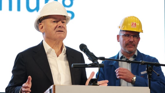 Bundeskanzler Olaf Scholz auf dem Weg zum Rednerpult bei einer Betriebsversammlung der Meyer Werft. © Markus Hibbeler/dpa Foto: Markus Hibbeler