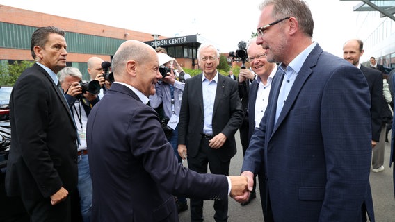 Bundeskanzler Olaf Scholz (SPD, 2.v.l) besucht die Meyer Werft in Papenburg und begrüßt den Betriebsratsvorsitzenden der Meyer Werft, Andreas Hansen. © Markus Hibbeler/dpa Foto: Markus Hibbeler