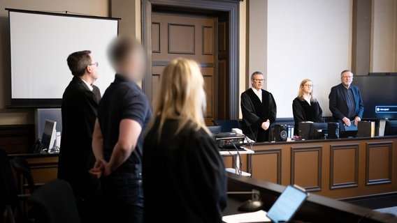 Verden: Ein Angeklagter steht neben seinen Verteidigern Daniela Post (vorn r) und René Lancker vor dem vorsitzenden Richter Volker Stronczyk (M) im Gerichtssaal vom Landgericht Verden. © dpa-Bildfunk Foto: Sina Schuldt