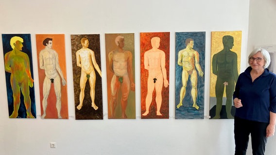 Kunstdozentin Brigitte Gläsel zeigt Bilder von gemalten nackten Männern - die entscheidende Stelle ist von einem Blatt verdeckt. © NDR Foto: Maren Momsen