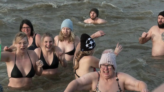 Menschen beim verspäteten "Anbaden" am 2. Januar 2025 in Norddeich © NonstopNews 