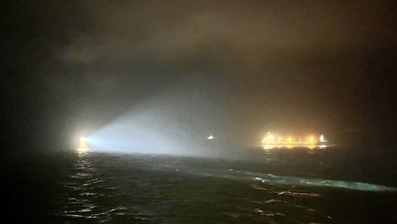 Suchscheinwerfer suchen das Wasser in der Nähe der Stelle ab, an der das britische Frachtschiff "Verity" nach einer Kollision mit dem Schiff "Polesie" in der Nordsee nahe der deutschen Insel Helgoland gesunken ist. © Handout/P&O/PA Media/dpa 