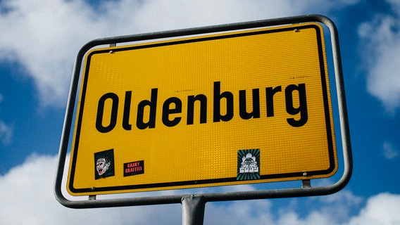 Vor blauem Himmel mit ein paar Wolken steht das gelbe Ortsschild von Oldenburg. © NDR Foto: Julius Matuschik