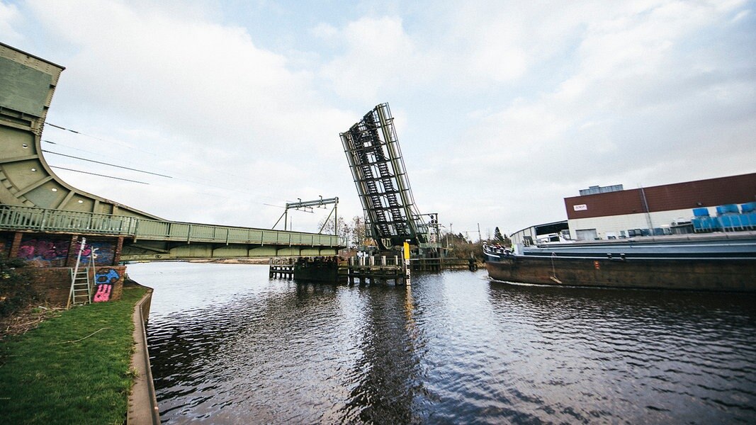 Ein Schiff fährt auf die geöffnete Eisenbahnklappbrücke über der Hunte in Oldenburg zu. 