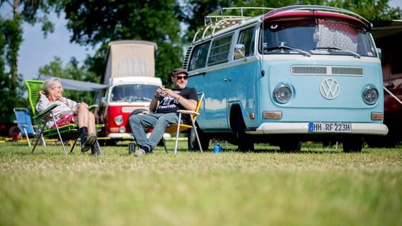 Christine und Ralf sitzen auf dem Bockhorner Oldtimermarkt vor ihrem Volkswagen T2 aus dem Jahr 1972. © Hauke-Christian Dittrich/dpa Foto: Hauke-Christian Dittrich