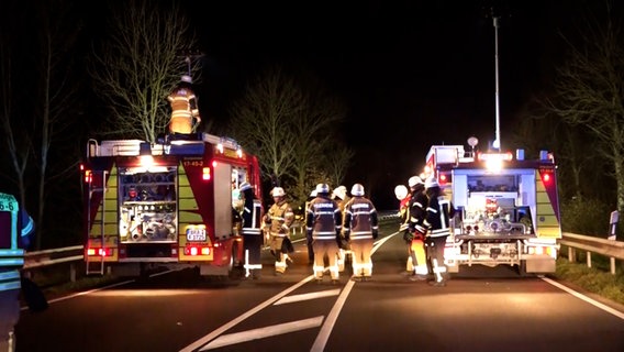 Einsatzkräfte der Feuerwehr stehen nach einem schweren Unfall in Ovelgönne auf der Straße. © NonstopNews 