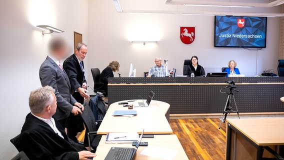 Der Angeklagte (2.v.l.) steht vor Prozessbeginn mit seinem Anwälten Reinhard Daum (3.v.l.) und Eric Sedlatzek (l) im Gerichtssaal im Amtsgericht Brake. © dpa-Bildfunk Foto: Sina Schuldt