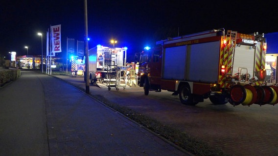 Feuerwehrleute sichern einen Bach und Gullys bei einer Tankstelle in Rastede, nachdem Kraftstoff abgelassen wurde. © Nord-West-Media TV 
