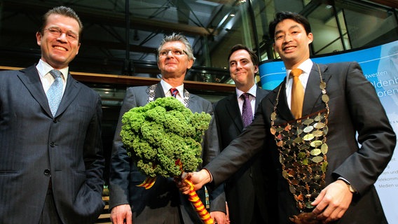 2011: Der neue Oldenburger Grünkohlkönig, Bundesgesundheitsminister Philipp Rösler (FDP, r.) erhält von seinem Vorgänger, Verteidigungsminister Karl-Theodor zu Guttenberg (CSU, l), Grünkohlstab und Grünkohlkette. Daneben stehen Oldenburgs Oberbürgermeister Gerd Schwandner ( 2.v.l.) und Niedersachsens Ministerpräsidenten David McAllister (2.v.r.). © picture alliance / dpa | Wolfgang Kumm Foto: Wolfgang Kumm