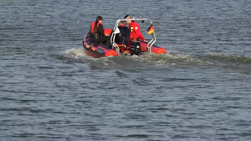 Wasserretter sind mit einem Boot auf einem See in Sande unterwegs.