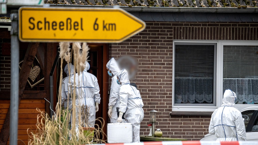 Beamte der Spurensicherung gehen zu einem Einfamilienhaus in der Gemeinde Scheeßel.