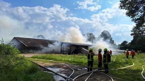 Feuerwehrleute löschen ein brennendes Strohlager. © Kreisfeuerwehr Rotenburg (Wümme) 