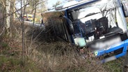 Ein Schulbus steht nach einem Unfall in einem Straßengraben. © Nord-West-Media TV 