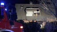 Die Fenster eines Wohnhauses sind nach einem Brand zerstört. © NonstopNews 