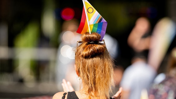 Eine Frau mit einer Regenbogenfahne im Haar. © dpa Foto: Jacob Schröter