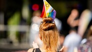 Eine Frau mit einer Regenbogenfahne im Haar. © dpa Foto: Jacob Schröter