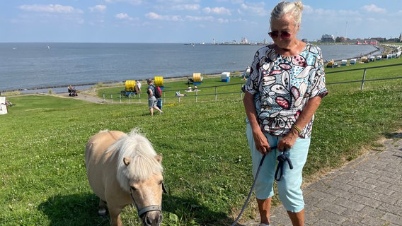 Sonja Weidhase und Fritzi am Deich vor der Grimmershörnbucht. © NDR Foto: Catherine Grim