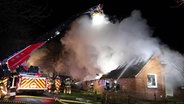 Brand eines Reetdachhauses in Stadland (Landkreis Wesermarsch). Rauch steigt auf. Die Feuerwehr ist im Einsatz. © NonstopNews 
