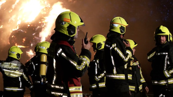 Feuerwehrleute löschen brennende Strohballen. © NonstopNews 