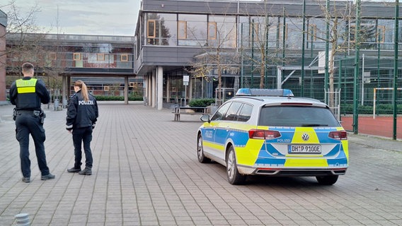 Polizeibeamte stehen vor der Lise-Meitner-Schule in Stuhr. © Nord-West-Media TV 