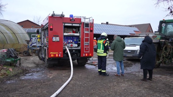 Feuerwehrleute stehen auf einem landwirtschaftlichen Hof auf dem ein Feuer mehrere Schweine und Ferkel getötet hat. © Nord-West-Media TV 