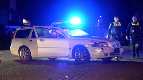 Zwei Polizisten gehen an einem Volvo nach einem Unfall in Syke vorbei. © Nord-West-Media TV 