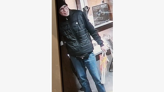 Ein Mann mit buntem Stoffbeutel, der einen Juwelier in Syke überfallen haben soll, wir von der Polizei gesucht. © Polizeiinspektion Diepholz 