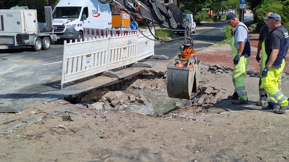 Zwei Arbeiter stehen mit einem Bagger an einer kaputten Wasserleitung in Wilhelmshaven. © Nord-West-Media TV 