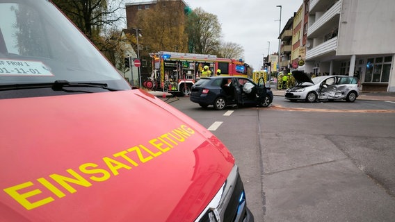 Zwei demolierte Autos auf einer Kreuzung, im Vorder- und Hintergrund Einsatzfahrzeuge der Feuerwehr © Feuerwehr Wilhelmshaven 