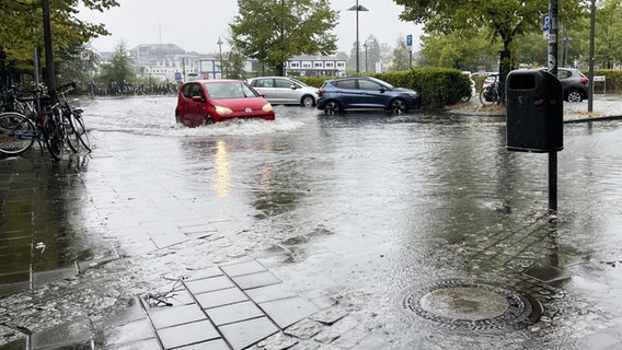 Ein Auto fährt in Oldenburg bei Unwetter über eine überschwemmte Straße. © NDR Foto: Mandy Mundt