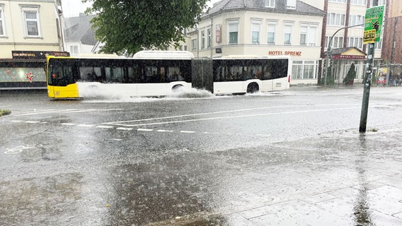 Ein Bus fährt in Oldenburg bei Unwetter über eine überschwemmte Straße. © NDR Foto: Mandy Mundt