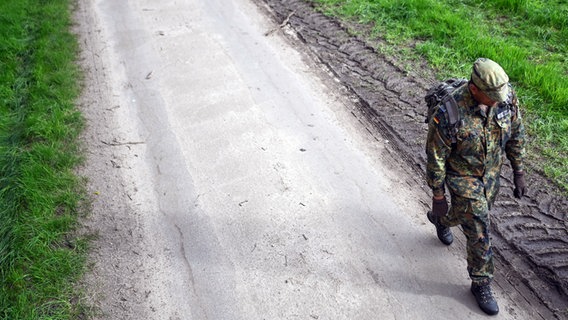 Ein Soldat der Bundeswehr geht einen Waldweg entlang, nachdem er ein Waldstück nach dem vermissten Arian aus Bremervörde abgesucht hat. © dpa Foto: Lars Penning