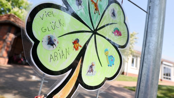 Bremervörde: "Viel Glück Arian" steht auf einem gebastelten Kleeblatt für einen vermissten Jungen, das an einem Zaun vor dem Bürgerhaus hängt. © dpa-Bildfunk Foto: Bodo Marks