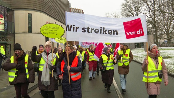 Eine Beschäftigte des Klinikums Oldenburg hält bei einem Warnstreik ein Plakat mit dem Text "8% mehr Lohn - weil Wertschätzung nicht nur Applaus ist!" © NDR 