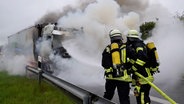 Feuerwehrleute löschen einen brennenden Lkw auf der A31. © NonstopNews 