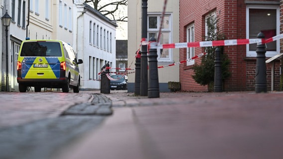 Ein Polizeiauto steht vor einem mit Flatterband abgesperrten Einsatzort in Weener (Landkreis Leer). © dpa - Bildfunk Foto: Lars Penning